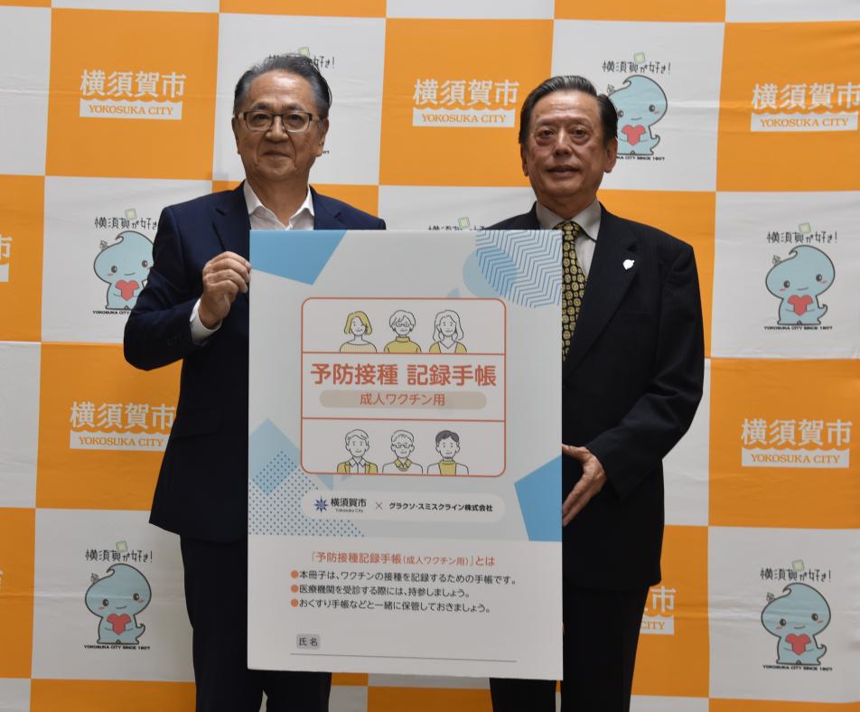 市長と医師会長がワクチン手帳を紹介する写真